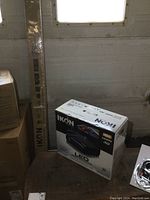 New Ikon IK200 LED projector box with model and features visible, with Ikon IS72 projector screen box standing beside it