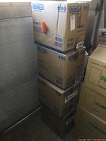 Four stacked sealed cardboard boxes labeled Ronco Maskin brand respirators.