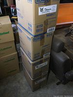 Tall stack of four Ronco Maskin cardboard cases with blue typeface labeling N95 valved respirators.