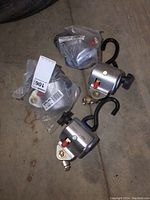 Four new Sure-Lok Series L auto locking crank retractors with metal crank handles and attached black S hooks, two out of the four are still in plastic packaging.