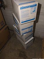 Stack of four unopened white boxes labeled Converter Critical Zone Impervious Resistant High Top Shoe Covers X-Large.