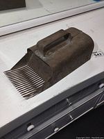 Antique metal blueberry picker showing top handle and side