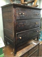 Front view of the antique dresser highlighting the three drawers with varied handles and visible surface wear.
