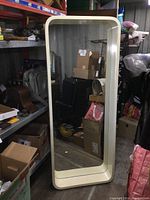 Front facing image of extra large rectangular mirror with off white wide rounded frame, showing reflection of room interior.