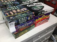 Photo of stacked boxed games including CSI, Trivial Pursuit, Othello, Cranium, Uno Extreme, and Casino Games 4-In-1.