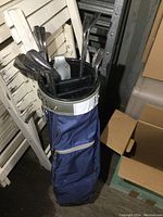 Full view of golf clubs set in blue golf bag in an indoor setting.