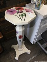 Octagon top of plant stand showing custom painted pink and orange flowers with green stems, and white background