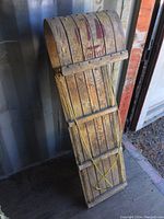 Front angled view showing wooden slat construction and attached yellow rope for steering or pulling.