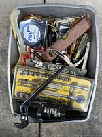 Top view of tray with assorted vintage tools showing socket set, measuring tape, wooden level, and hand tools