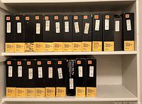 Shelf with multiple Kodak Carousel Transvue 140 Slide Tray boxes with yellow labels and various handwritten notes.