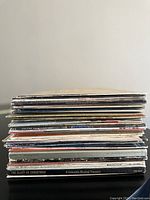Side view of stacked vintage vinyl records showing various album spines with titles and labels.