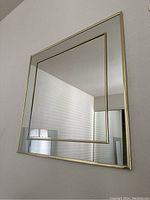 Full front view of a square vintage wall mirror with gold frame and dual border design.