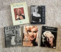 Top view of five Marilyn Monroe books arranged on carpet showing cover details