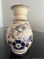 Front view showing hand-painted bird and floral design on the vase
