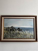 Frontal view of vintage Helen Mason seascape oil painting showing coastal cliffs, ocean, foreground grasses, and sky within gold decorative frame.