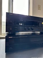 Yamaha RV-702 receiver on top of Yamaha CDC-502 CD player, showing front panel with control knobs and buttons.