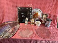 Full display of assorted Christmas decorative items including two glass platters and figurines
