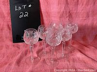 Six crystal goblets arranged to show clear view of cut pinwheel designs on each glass bowl.