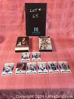 Full lot with cards arranged in front of two VHS tapes and a display board showing the lot number