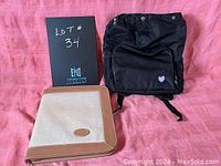 Both black insulated knapsack and taupe/brown padfolio shown together on pink cloth background.