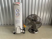 Side view of Honeywell Plus electric heater and Vornado fan showing overall condition and setup.