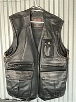 Front view of the black Xpert leather vest showing multiple pockets and smooth leather finish.