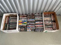 Overview of four groupings: one letter-size box, two floor stacks, one smaller box containing DVDs.