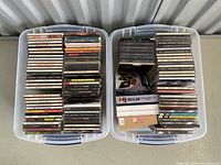 Two plastic bins filled with stacks of jazz CD jewel cases arranged side by side.