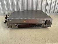 Front and top view of Sony MDP Laser Disc Player showing overall unit with power cord, disc tray, and control panel.