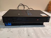 Front view of Sony PS2 console showing memory card slots and controller ports.