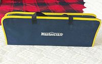 Mastercraft case front view showing blue fabric with yellow trim and black handles on red and white background.