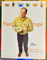 Front cover of the Pasta for Wimps cookbook featuring Carlo Lai holding a plated pasta dish.