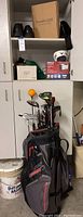 Wide shot of golf bag and accessories inside cabinet