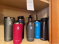 Photo showing all seven water bottles arranged on wooden shelf, highlighting brand logos and colors