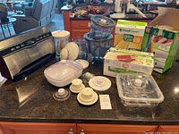 Overview of all items included: vacuum sealer main unit, several vacuum containers with lids, and boxes of replacement vacuum bags.