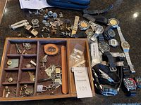 Overview of entire lot showing cufflinks, watches, watch parts, wooden organizer tray, multi-tool, and watch repair kit.