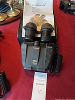 Binoculars, printed manual and soft case on table