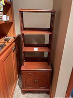 Front view of the vintage Chippendale style bookcase with open shelves and closed cabinet at the bottom.