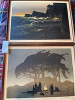 Overview of both framed serigraphs: cliffside seascape above campfire scene beneath trees.