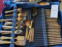 Full case view showing top row of serving pieces and rows of flatware in foam slots