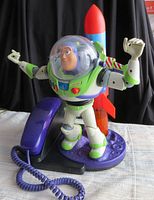 Front view of the Buzz Lightyear telephone figure with purple handset and rocket stand