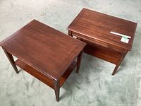 Pair of wooden end tables shown side by side on carpet floor, displaying overall size and finish.