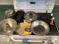 Overview of assorted bakeware items laid out on kitchen stove.