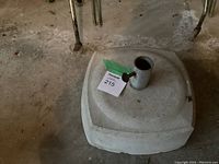 Top view of the square cement umbrella stand showing the metal holder with tightening knob and the rough cement texture.