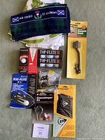 Overall view of the lot showing multiple golf balls, glove, club cleaning brush, golf towel, 5-in-1 golf tool, and Greenskeeper kit.