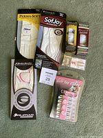 Photo showing all items in the lot: three ladies golf gloves from Titleist, FootJoy, and Gulimar; two boxes of Pinnacle golf balls; and a pink golf tee caddy.