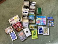 Top view showing a large collection of various playing cards in boxes, including Bicycle decks and themed decks.