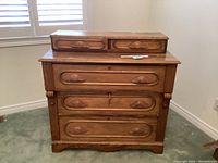 Front view of the vintage wooden buffet/dresser showing the drawer fronts and top tier drawers.