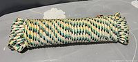Photo showing coiled new rope with a cream base color and green and yellow woven pattern