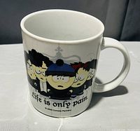 White ceramic mug featuring South Park characters in gothic attire with text 'Life is only pain' and copyright 2009 Comedy Partners.